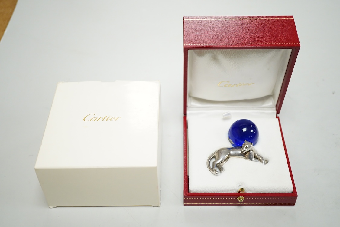 A recent Cartier paperweight, modelled as a recumbent 925 panther with blue glass sphere(a.f.), signed, in original fitted Cartier box, 56mm by 60mm.